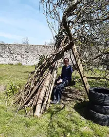 A walled garden with log seats and outdoor cooking facilities